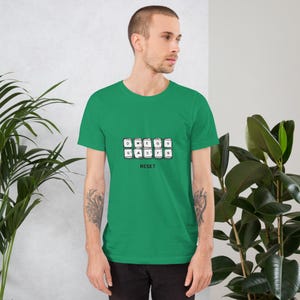 May include: A green t-shirt featuring a keyboard key design with the letters D, W, E, G, S, A, S, F, and Q, and the word "RESET" below. The shirt is made of a soft material.