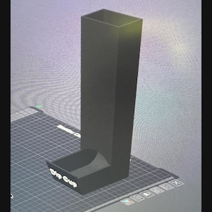 May include: A black, tall, rectangular 3D-printed tower with an open top and a wide base featuring a curved ramp leading to a small tray. The front of the tray displays the white text "DIP CUP" in a bold, sans-serif font on the exterior surface.