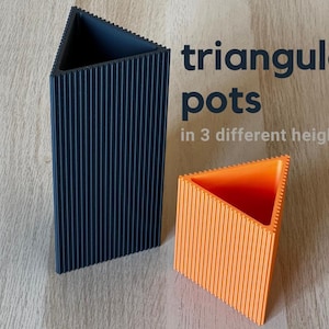 May include: A tall dark blue triangular pot and a shorter orange triangular pot, both featuring a vertical ribbed texture on the exterior. The text "triangular pots in 3 different heights" is printed in dark blue and light gray on the right side.