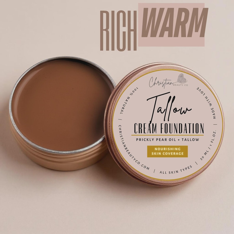 May include: An open, round, metal tin of brown cream foundation next to a closed tin. The closed tin has a label that reads "Tallow Cream Foundation" and "Nourishing Skin Coverage". The text "Rich Warm" is at the top.