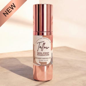 Könnte beinhalten: Eine zylindrische Foundation-Flasche mit einem metallischen roségoldenen Verschluss und Boden. Das Etikett zeigt den Text Christian Beauty Co, Tallow Skin-First Foundation, Niacinamide + Panthenol + HA und Net 30 ml / 1.01 fl oz sowie ein Kuh-Symbol.