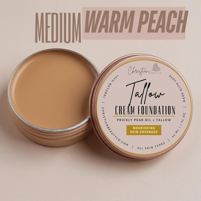 May include: A tin of "Medium Warm Peach" Tallow Cream Foundation, with the lid off, revealing the product. The label reads "Christian Beauty Co" and "Nourishing Skin Coverage". The product is for all skin types and is 30 ml / 1 fl oz.