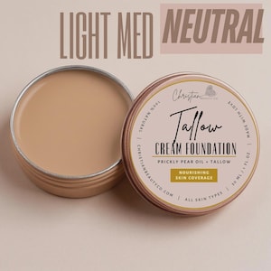 May include: Open tin of light-medium neutral-toned cream foundation next to a closed tin. The label reads "Tallow Cream Foundation" with "Prickly Pear Oil + Tallow" and "Nourishing Skin Coverage" text. The product is 100% natural and suitable for all skin types.