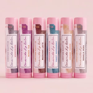 Puede incluir: Seis tubos cilíndricos de bálsamo labial con tapas y bases rosas, etiquetados Christian Beauty Co Ceramide Lip Balm. Los sabores son Unscented, Honey Tea, Hazelnut Latte, Sweet Peppermint, Creamy Toffee y Vanilla Bean, cada uno con 4,25 gramos.