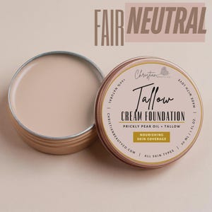 May include: Open, round, metal tin of Fair Neutral Tallow Cream Foundation. The lid is off, revealing the creamy product. The label reads "Tallow Cream Foundation" with "Prickly Pear Oil + Tallow" and "Nourishing Skin Coverage".