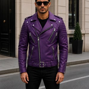 Man wearing purple leather biker jacket with quilted sleeves, asymmetrical front zipper and belted waist in an urban evening setting.
