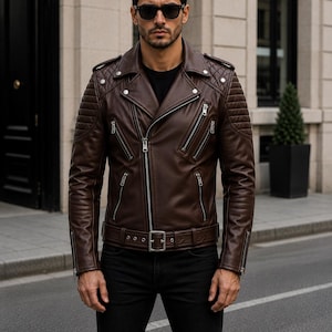Man wearing chocolate brown leather biker jacket with quilted sleeves, asymmetrical front zipper and belted waist in an urban evening setting.