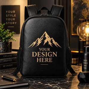 May include: A black backpack featuring a gold mountain graphic and the text "YOUR DESIGN HERE" printed on the front. The backpack has two shoulder straps, a top handle, and black mesh side pockets, with a smooth, matte-textured exterior finish.