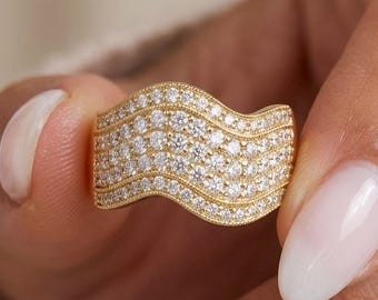 Anello vistoso color oro massiccio con motivo a onda: fascia larga con moissanite pavé e lavorazione milgrain.