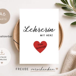 Könnte beinhalten: Eine weiße Karte mit den Worten "Lehrerin MIT HERZ" in schwarzer Schrift, einem roten Herz mit "Frau Schmidt" darin und dem Satz "FREUDE verschenken" unten. Die Karte liegt auf einem Holztablett.