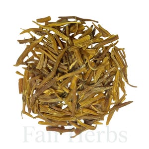 Finely ground Shatavari powder in a wooden bowl beside dried roots
