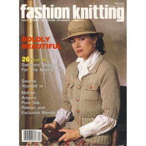 May include: Cover of "Fashion Knitting" magazine, featuring a woman in a tan knit jacket and hat. The cover text includes "Boldly Beautiful" and "26 Knit Me Sweaters Designed For The Main Event."