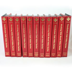 May include: A set of 12 red VHS tapes with gold lettering. The tapes are labeled "Handyman Club Video Series" and "Working With Wood Video Series".