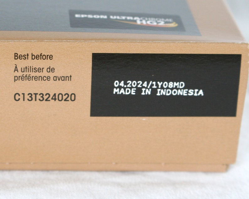 K&ouml;nnte beinhalten: Ein schwarz-wei&szlig;es Etikett mit dem Text "Best before", "&Agrave; utiliser de pr&eacute;f&eacute;rence avant", "C13T324020", "04.2024/1Y08MD" und "MADE IN INDONESIA".