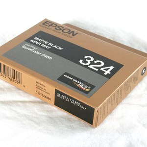 May include: A brown box with the text "EPSON" and "MATTE BLACK NOIR MAT" printed on it. The box also has the text "SureColor P400" and the number "324" printed on it.