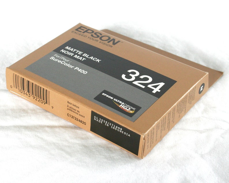 May include: A brown box with the text "EPSON" and "MATTE BLACK NOIR MAT" printed on it. The box also has the text "SureColor P400" and the number "324" printed on it.