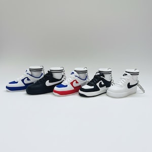 May include: Five miniature sneakers in various color combinations: blue and white, black and white, red and white, black and white, and white and black. Each sneaker has a small keychain and a miniature sock.