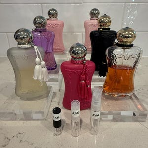 May include: A set of three ceramic mugs with a speckled, matte finish. The mugs are in shades of cream, light gray, and dark gray. Each mug has a simple, minimalist design, perfect for coffee or tea. The mugs are stacked on top of each other.