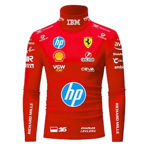 Puede incluir: Una camiseta roja de manga larga con cuello alto con múltiples logotipos y texto. Los logotipos incluyen "hp", "Shell" y "Ferrari". La camiseta también presenta el texto "RICHARD MILLE", "CHARLES LECLERC" y el número "16".