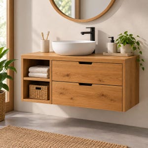 May include: A wall-mounted light wood bathroom vanity featuring two horizontal drawers with recessed pulls, an open shelving unit with two stacked white towels and a woven basket, and a white vessel sink with a black faucet.