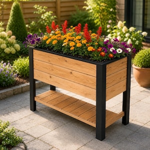 May include: A rectangular wooden planter box with a black metal frame and a lower storage shelf. The planter is filled with a vibrant arrangement of red salvia, orange marigolds, and purple petunias, creating a dense display of colorful flowers.