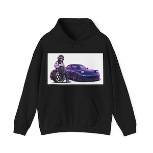 Könnte beinhalten: Schwarzer Kapuzenpullover mit einer Grafik eines lila Sportwagens und einer Waschbärfigur. Der Waschbär trägt eine Jacke und einen Hut und lehnt an einem großen Reifen. Das Auto hat seine Scheinwerfer an.
