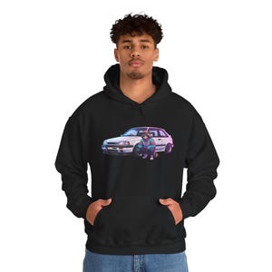 Könnte beinhalten: Schwarzer Kapuzenpullover mit einer Grafik eines weißen Autos und einer Person in farbenfroher Kleidung. Die Grafik hat einen Retro-Anime-Stil. Der Pullover hat eine Kängurutasche und eine Kapuze mit Kordelzug.