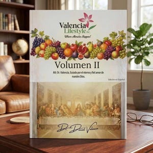 May include: A hardcover book titled Valencia Lifestyle Inc. Volumen II featuring a colorful illustration of assorted fruits including grapes, apples, and a pomegranate at the top and a depiction of The Last Supper at the bottom with text.