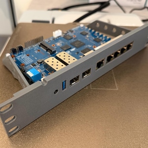 May include: A gray metal server rack with a blue circuit board. The circuit board has various components, including chips, connectors, and ports. The rack has several ports and slots for connections.