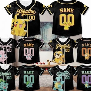 May include: A collection of black baseball jerseys featuring various Pokemon characters including Pikachu, Jigglypuff, Psyduck, Bulbasaur, and Squirtle. Each jersey displays a character graphic, the name of the character, and the number 00 in yellow.