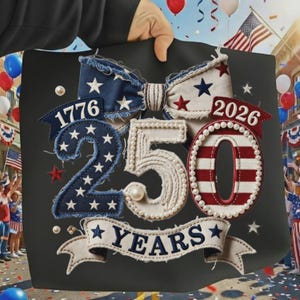May include: A black tote bag with a patriotic design celebrating 250 years. Features a bow, the numbers "1776" and "2026", and the words "250 YEARS" in a banner. The design incorporates stars and stripes in red, white, and blue.