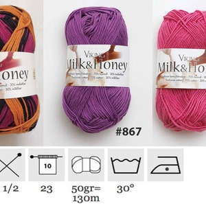 May include: Three skeins of Viking Milk & Honey yarn in various colors. One skein is a mix of black, orange, and pink. The other two are solid colors, purple and pink. Each skein has a label with the yarn name and number.