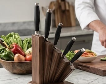 May include: A set of five kitchen knives with black handles and silver bolsters, arranged in a tiered, dark brown wooden block. The knives are positioned in descending order of height, with the tallest knife on the left and the shortest on the right.