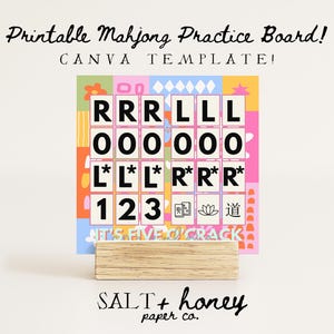 以下が含まれることがあります： 「Printable Mahjong Practice Board! CANVA TEMPLATE!」のテキストが入った、カラフルな印刷可能な麻雀練習ボード。ボードには文字と数字のグリッドがあり、木製のベースが付いています。画像の下部には「SALT + honey paper co.」の文字があります。