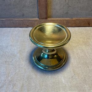 Peut inclure: Un objet doré de style piédestal avec un dessus et une base arrondis. L'objet a une surface brillante et réfléchissante et semble être en métal. Le design est simple et élégant, adapté à des fins décoratives.