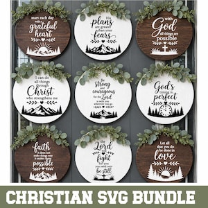 May include: A collection of nine circular wooden signs featuring white or dark brown finishes, each topped with green eucalyptus foliage. The signs display various Christian-themed quotes in black text, including mountain, clock, and cross graphics.