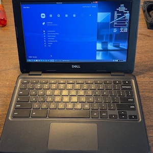 May include: A black Dell laptop with a QWERTY keyboard and a trackpad. The screen displays a blue RetroArch interface with a menu list, including options like Load Core, Load Content, and Information, alongside system status text in the corner.