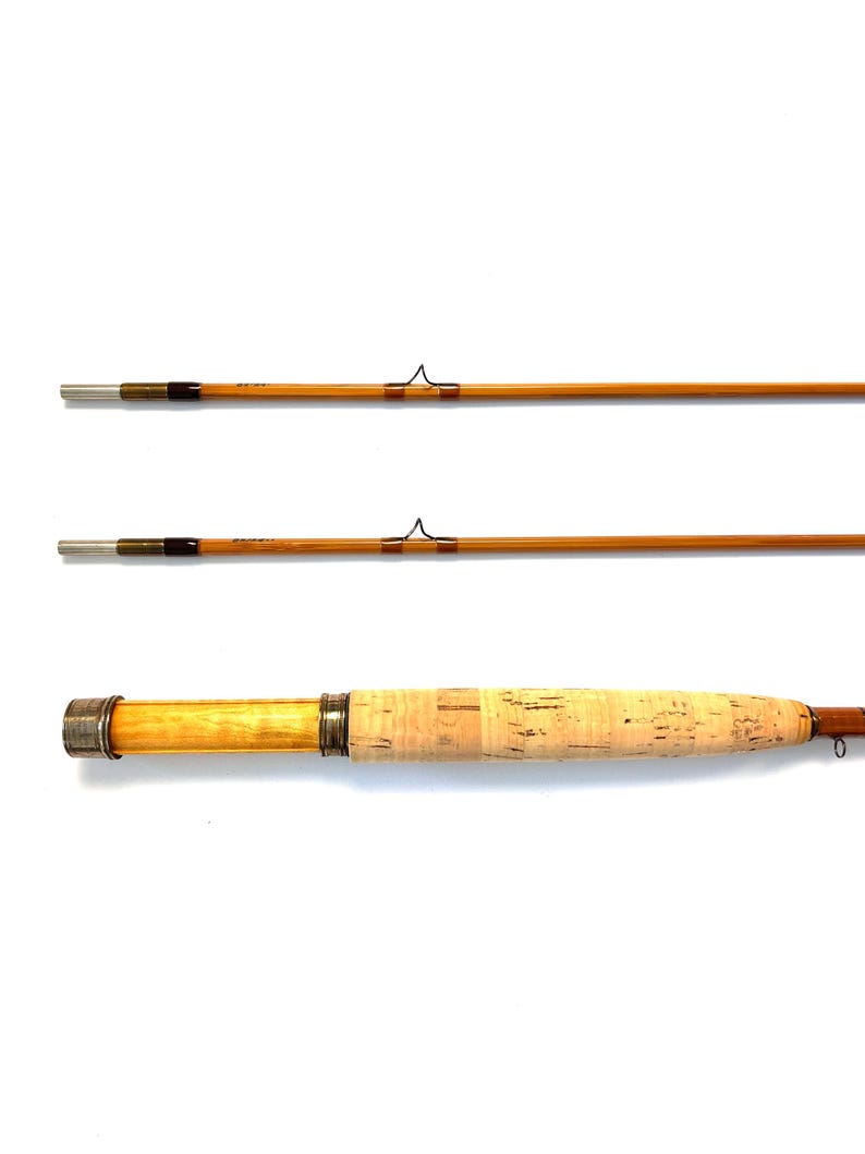 Peut inclure: Canne &agrave; p&ecirc;che &agrave; la mouche en trois parties avec une poign&eacute;e en li&egrave;ge de couleur claire et un f&ucirc;t en bambou. La canne a des accents m&eacute;talliques argent&eacute;s et un enroulement brun fonc&eacute;. Con&ccedil;ue pour la p&ecirc;che &agrave; la mouche.