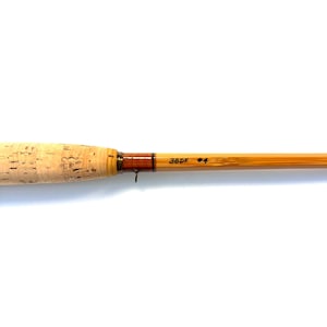 Peut inclure: Une canne &agrave; p&ecirc;che &agrave; la mouche avec une poign&eacute;e en li&egrave;ge et un f&ucirc;t brun clair. Le f&ucirc;t porte l'inscription "38DF #4". La canne est con&ccedil;ue pour la p&ecirc;che &agrave; la mouche.