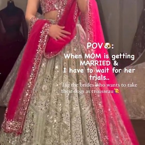 A person wearing a light green lehenga skirt with silver embroidery and mirrors, a dark red embroidered choli, and a hot pink net dupatta, with text overlaying the image.