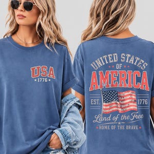 Celebrate American pride with this vintage-inspired USA patriotic shirt featuring bold “United States of America” graphics and a distressed American flag design. Perfect for Fourth of July celebrations, patriotic family gatherings, fireworks nights, Memorial Day events, Veterans Day, and summer Americana outfits. This stylish patriotic tee combines retro red, white, and blue aesthetics with comfortable everyday fashion, making it an ideal choice for proud Americans who love timeless USA-inspired