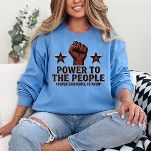 Perfect for individuals who value freedom of expression, activism, and meaningful graphic apparel. This design works well on both t-shirts and sweatshirts, providing a stylish yet expressive piece that communicates strength, unity, and civic engagement through fashion.