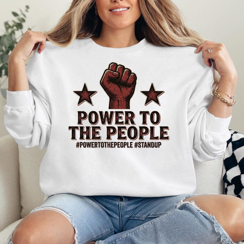Whether worn casually, at gatherings, or as a conversation starting outfit, this shirt adds a bold statement to everyday style. The balanced combination of strong typography and symbolic imagery creates a graphic that is both eye-catching and meaningful.
