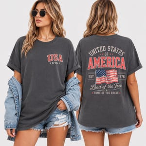 This retro patriotic USA shirt is designed for women who love classic Americana fashion and vintage American flag graphics. Featuring “Land of the Free” and “Home of the Brave” artwork, this comfortable graphic tee is perfect for Independence Day celebrations, summer vacations, BBQ parties, patriotic festivals, country concerts, and casual everyday wear. The distressed vintage look creates a timeless all-American aesthetic that pairs beautifully with denim shorts, jeans, or layered jackets.