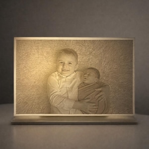 May include: A rectangular, illuminated photo frame shows a sepia-toned image of two children. One child smiles while holding a baby. The frame has a light base and a soft, warm glow, creating a comforting ambiance.