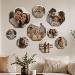 Op de afbeelding: Een verzameling van acht achthoekige wandpanelen met diverse familiefoto's. De afbeeldingen tonen portretten van koppels, kinderen en een gezin dat op een strand loopt, gerangschikt in een groep op een neutrale muur boven een bank.