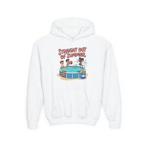 Peut inclure: Un sweat-shirt à capuche blanc orné d'une illustration colorée de trois enfants jouant dans une piscine hors-sol bleue. Le texte au-dessus de l'image indique "STRAIGHT OUT OF SUMMER" en lettres rouges. Le motif inclut un ballon, une glacière et un chapeau.