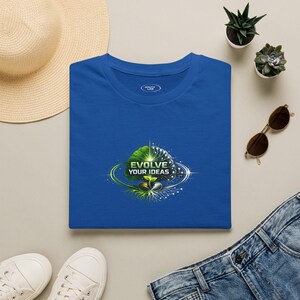 Könnte beinhalten: Ein königsblaues T-Shirt mit einer zentralen Grafik eines Gehirns, das zwischen einer grünen, blättrigen Seite und einer digitalen Schaltkreisseite geteilt ist, mit einem kleinen Keimling an der Basis und dem Text "EVOLVE YOUR IDEAS" in weißen Großbuchstaben.