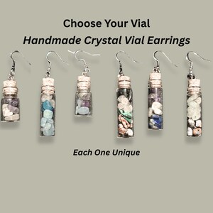 May include: Handmade crystal vial earrings with silver hooks. Each earring features a small glass vial filled with colorful crystals and sealed with a cork. The text reads: "Choose Your Vial Handmade Crystal Vial Earrings Each One Unique."