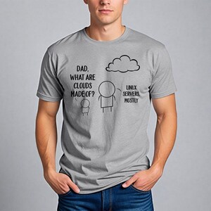May include: A grey t-shirt with a humorous graphic. The graphic shows a stick figure conversation with the text "DAD, WHAT ARE CLOUDS MADE OF?" and "LINUX SERVERS, MOSTLY" with a cloud illustration.